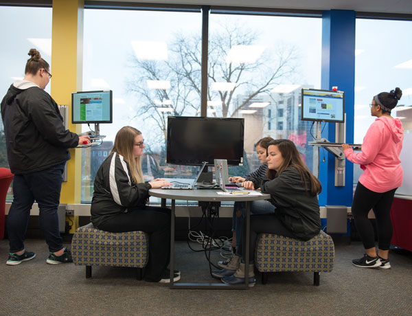 Students sit at a table studying together.