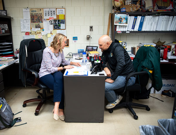 Two instructors discuss their lesson plans.