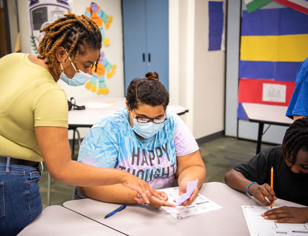 A student teacher helps her student with an assignment.