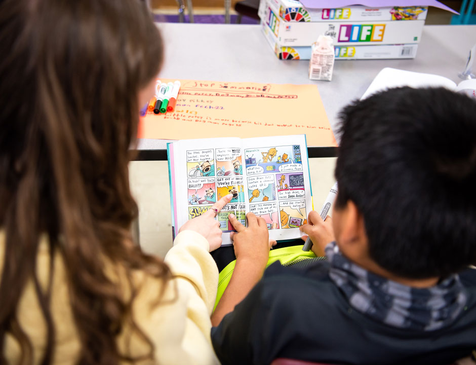 A student teacher reads with a student.