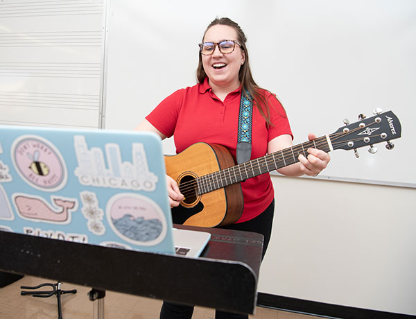 Music Therapy graduate student Taylor Stengren plays the guitar in a session over Zoom.