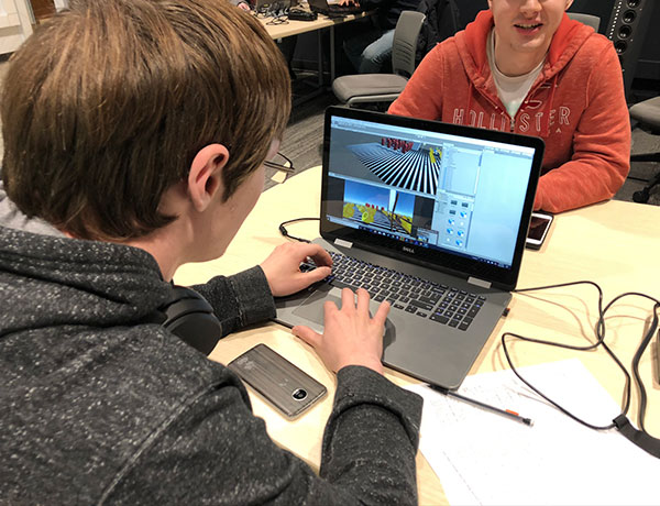 Male student’s laptop shows him working in Unity to create a video game.
