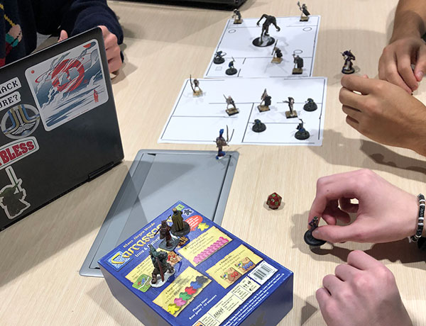 Students play a table-top game in game design class.