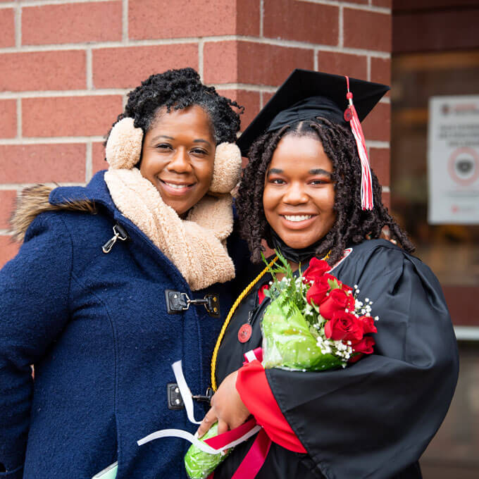 A graduate poses for a photo with their guest.