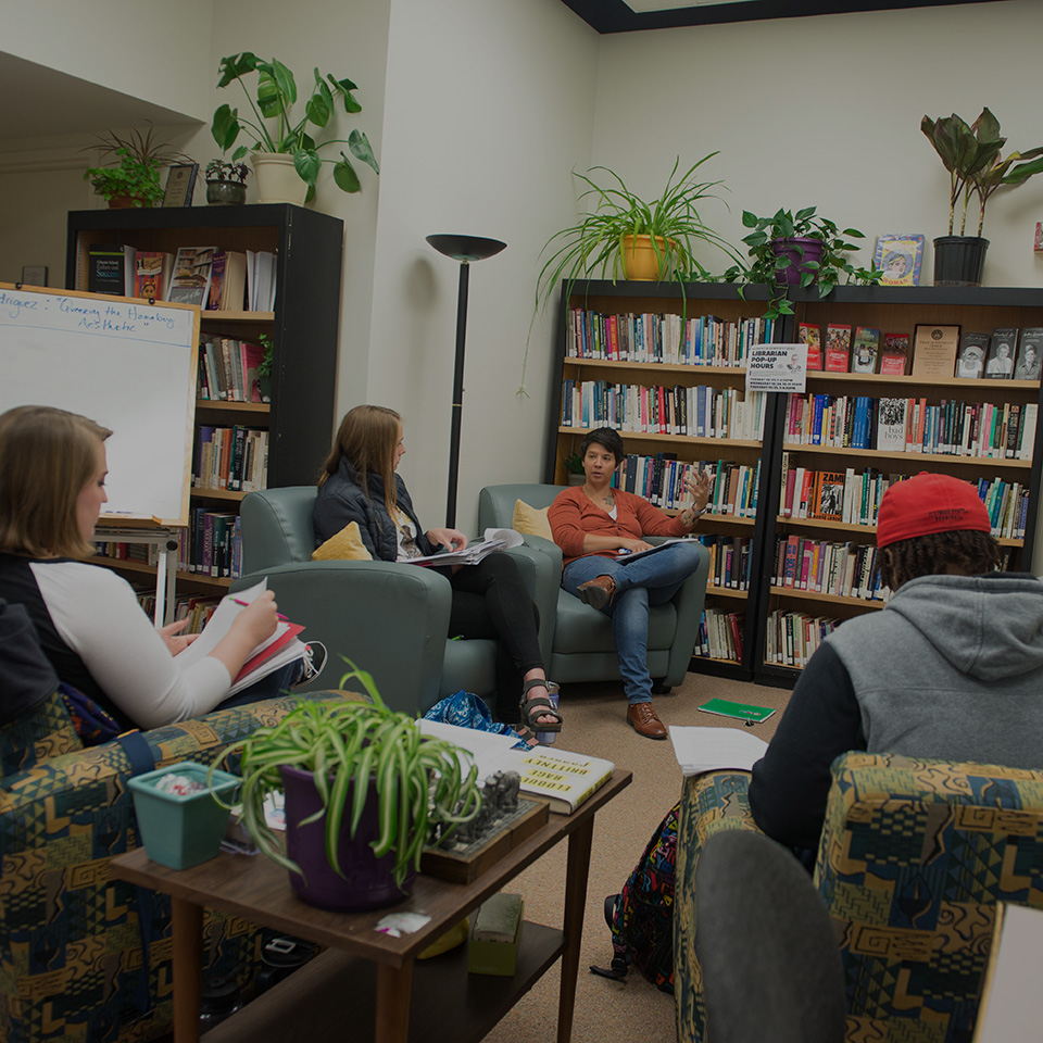 Students in discussion sitting in the Women's, Gender, and Sexuality Studies Library.