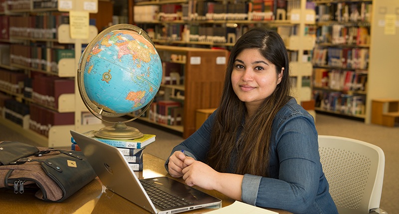 Female international student posing in Milner Library.