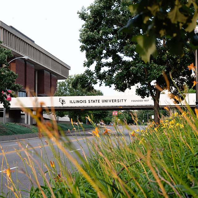 University campus with a modern building and 'Illinois State University' on an overpass.