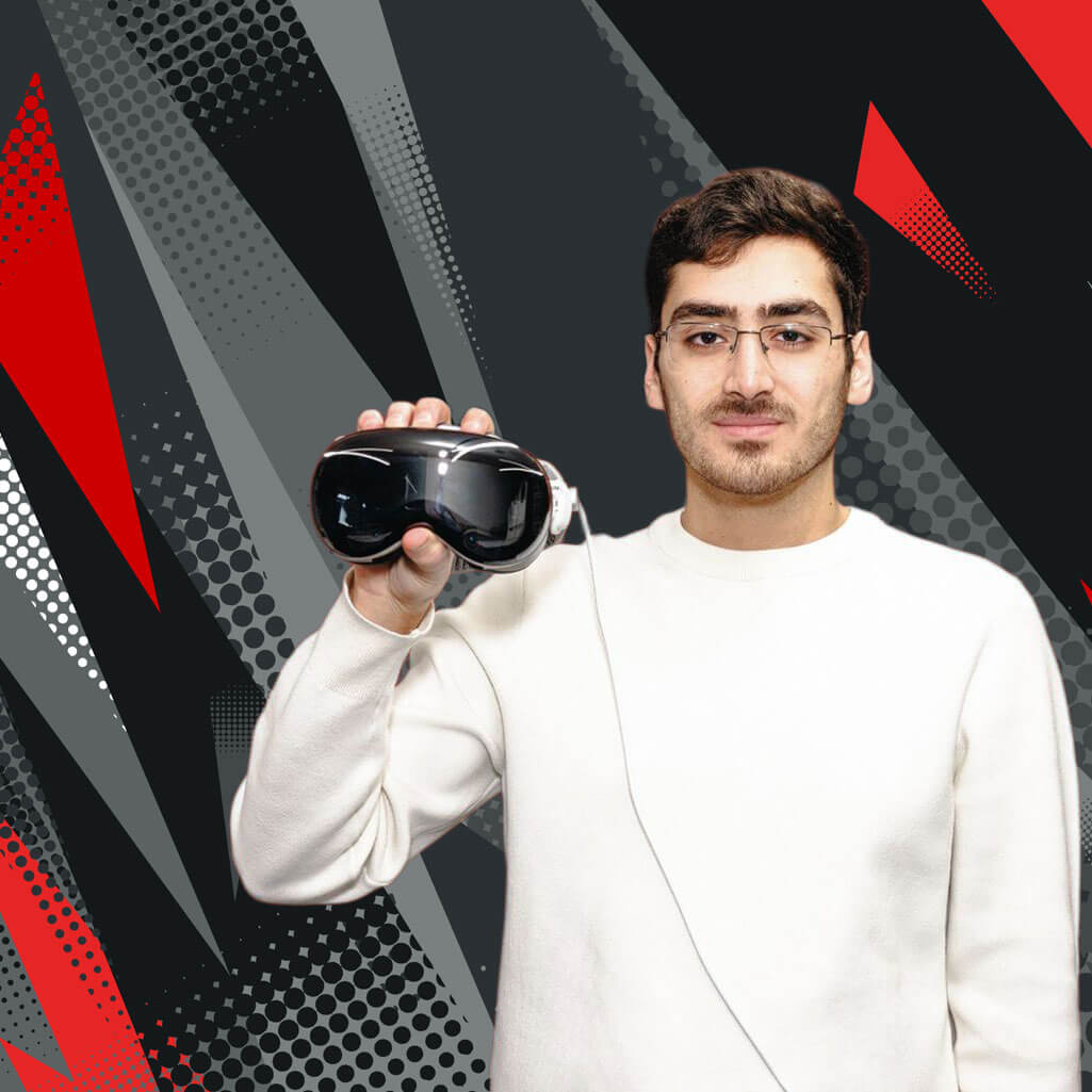 A person in a white sweater holding a virtual reality headset in front of a geometric, black, gray, and red background.