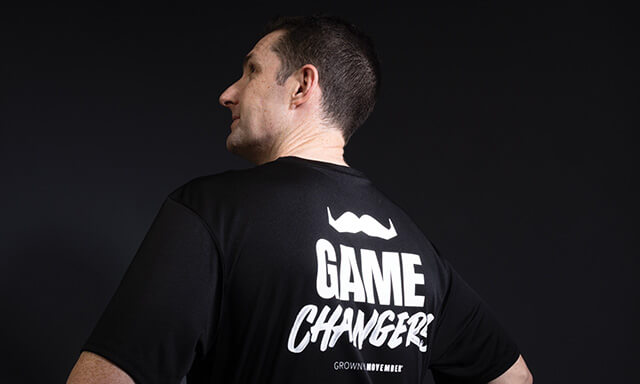Person wearing a black T-shirt with 'GAME CHANGERS' printed on the back.