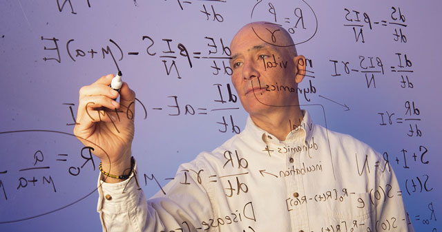 Person writing equations on a transparent screen with a white marker.