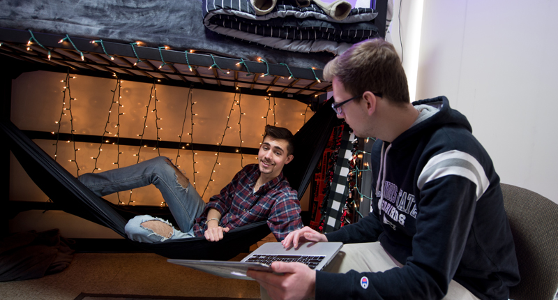 Two students hanging out in their dorm room.