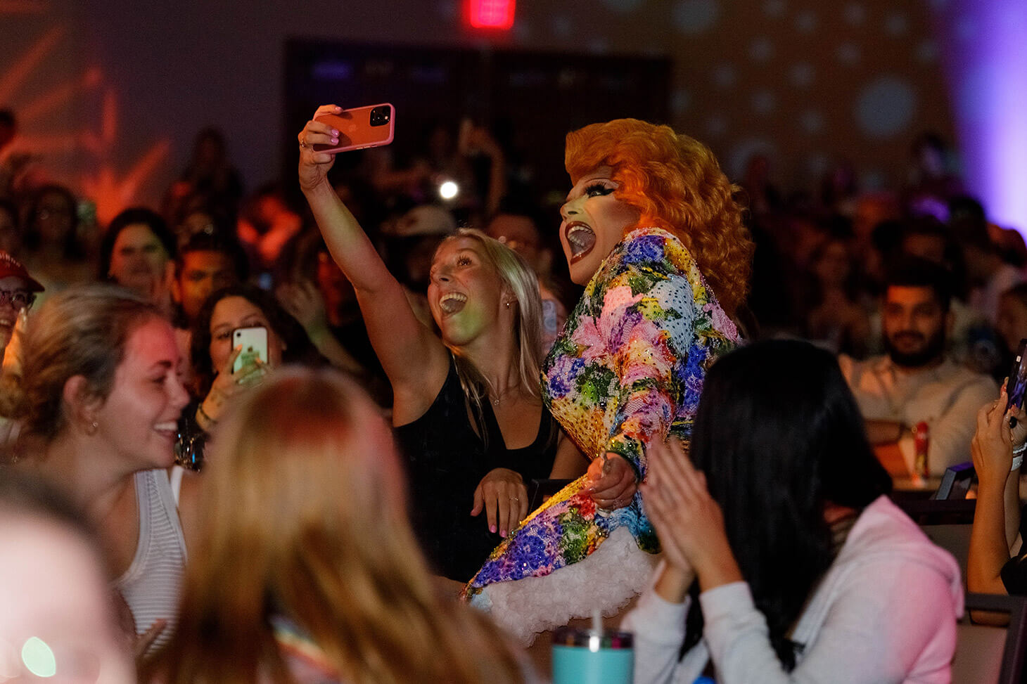 Student taking a selfie with one of the performers at Drag Queen Bingo.