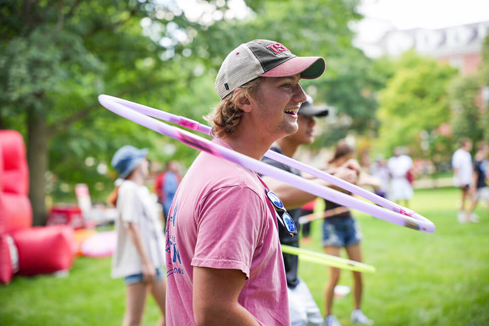 Student with a hula hoop around their neck at Fun in the Sun event on the Quad.
