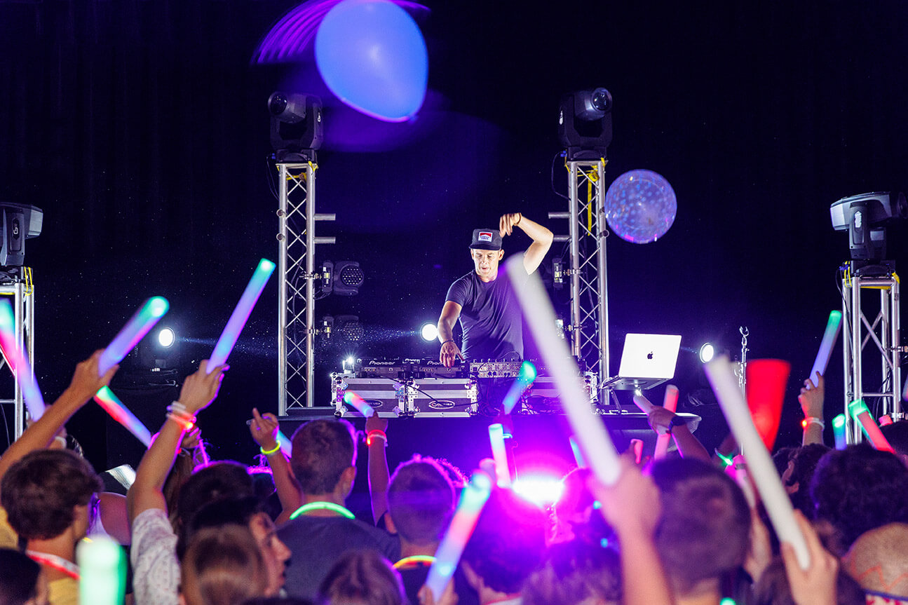 EDM DJ on stage at Let's Glow event in the Brown Ballroom.
